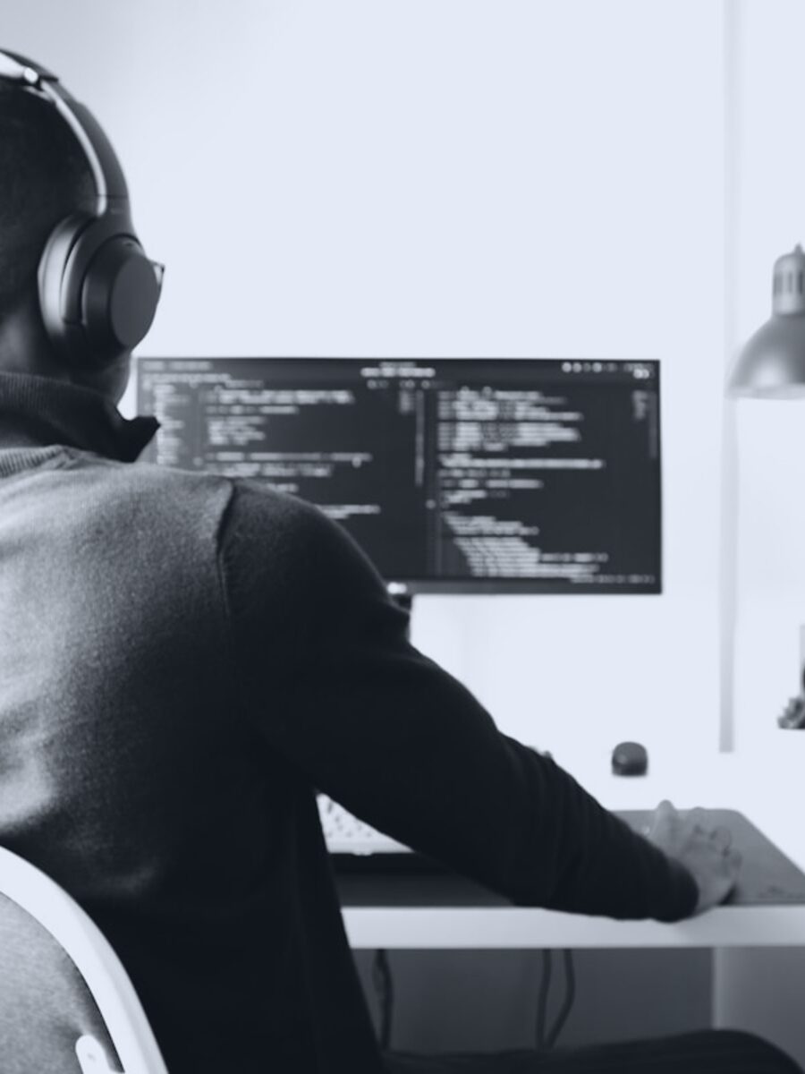 A developer at their monitor with code on screen. Photo by Nubelson Fernandes.